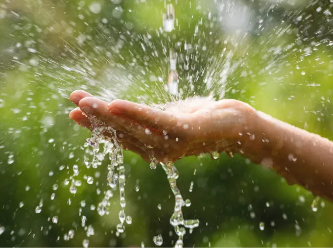 Extended hand catching splashing water.