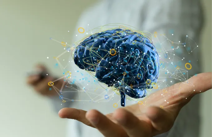 Computer image of brain floating above a person's open palm.