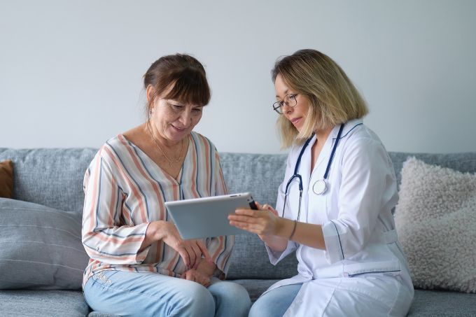 Healthcare professional showing a tablet screen to a patient.