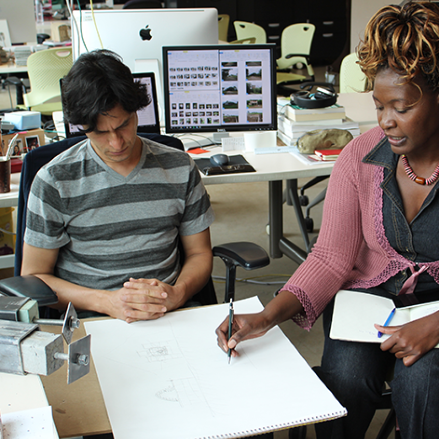 two people in a lab collaborating on work.