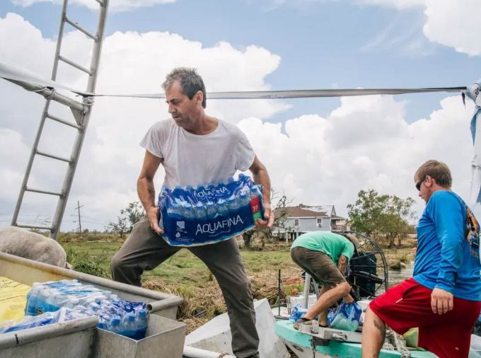 Community residents help with transporting water on September 1 in Jean Lafitte, Louisiana.