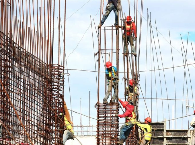 Construction workers assembling a structure with rebar.