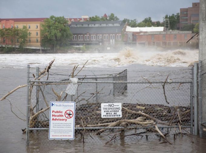 Flooded town with Public Health Advisory and No Tresspassing signs.