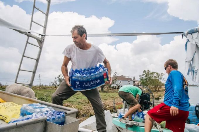 Community residents help with transporting water on September 1 in Jean Lafitte, Louisiana.